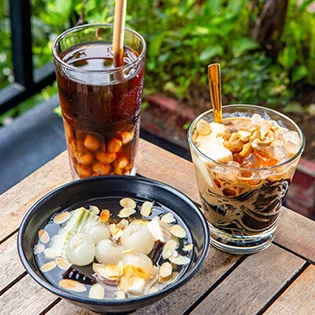 Hình ảnh chè khúc bạch cà phê 2026 với khúc bạch mềm mịn, hương cà phê thơm đậm, topping hạnh nhân và trái cây hấp dẫn.